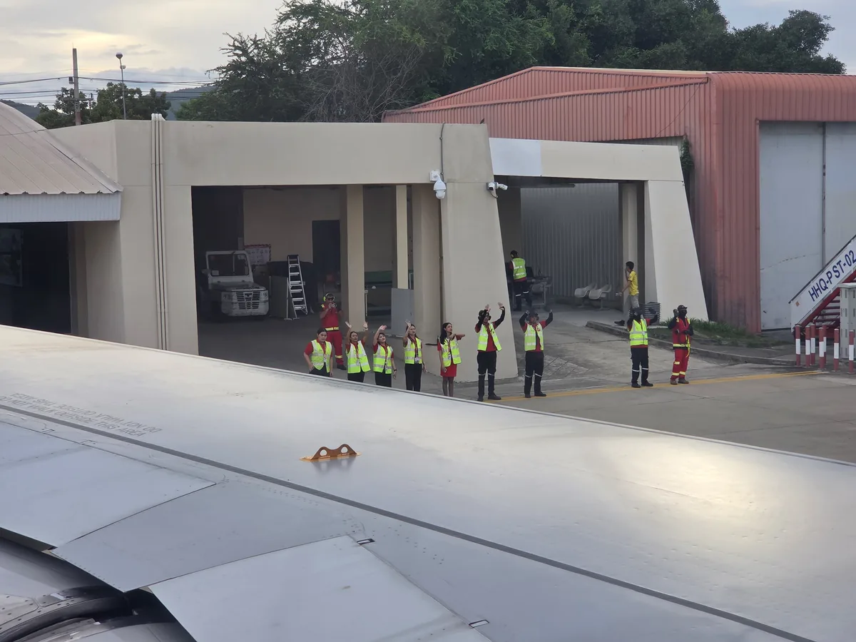 Ground crew waving goodbye to the plane
