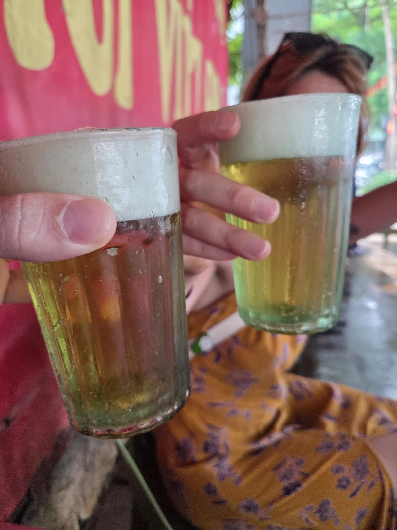 Daniel and Noela clinking cold glasses of beer in Hanoi