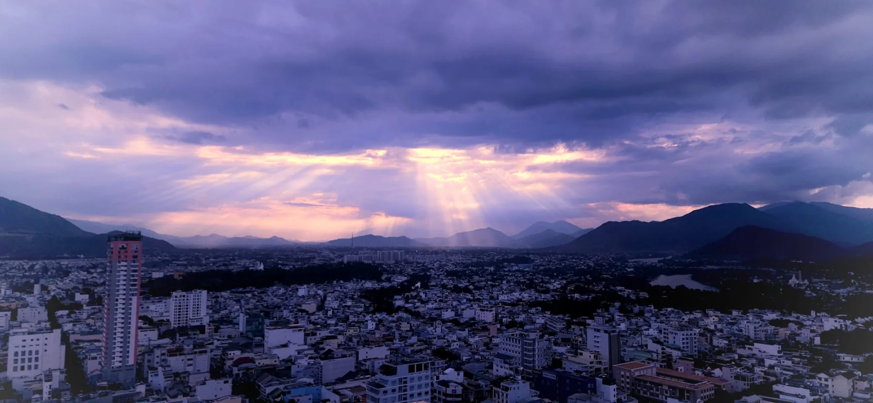 Sun rays breaking through storm clouds over Nha Trang and its surrounding mountains
